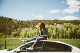 lady sitting on top of a car 