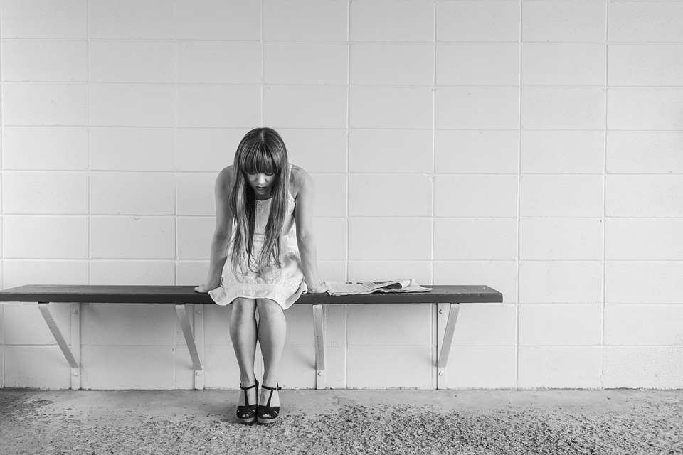 woman sitting looking at her feet 