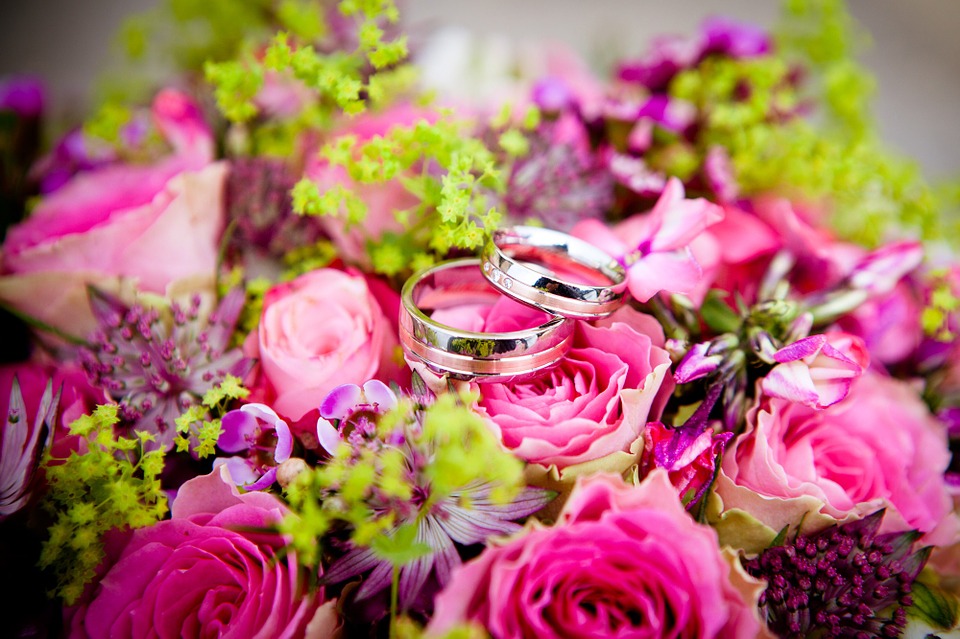 wedding rings on top of a bouquet 