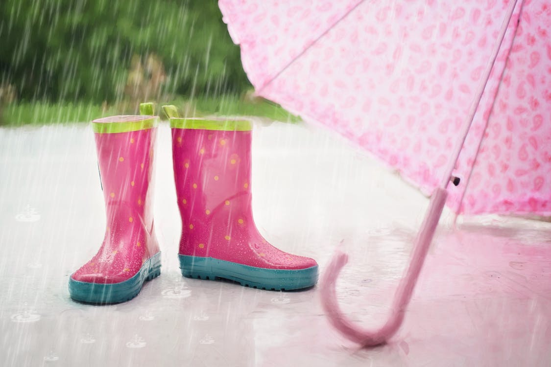 Kids boots and umbrella in the rain