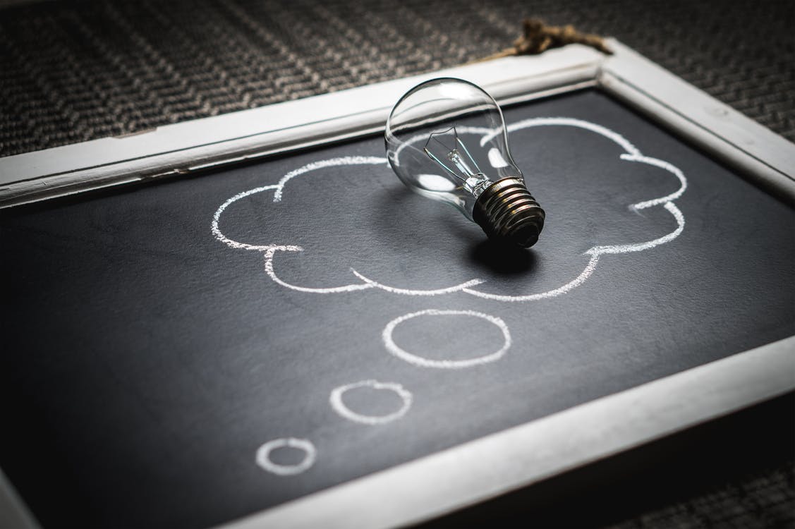 a lightbulb on top of a blackboard 