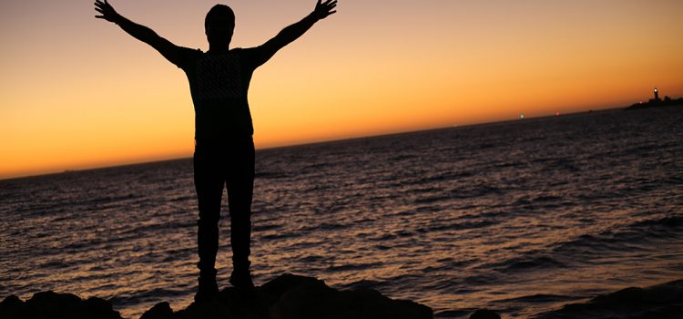 man silhouette standing at the beach